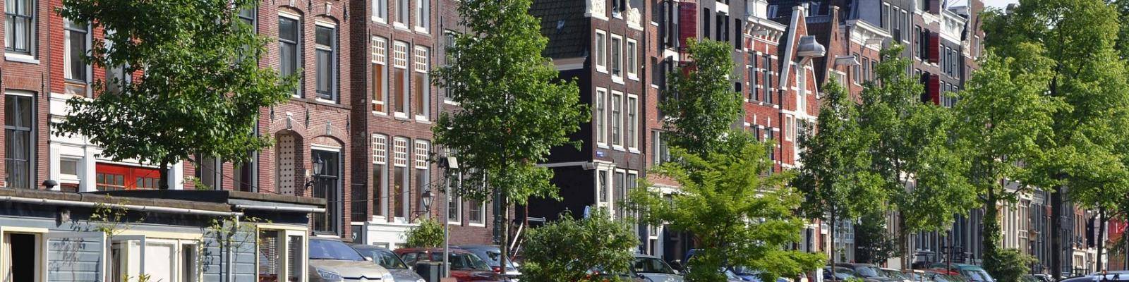 Straatbeeld met herenhuizen en auto's